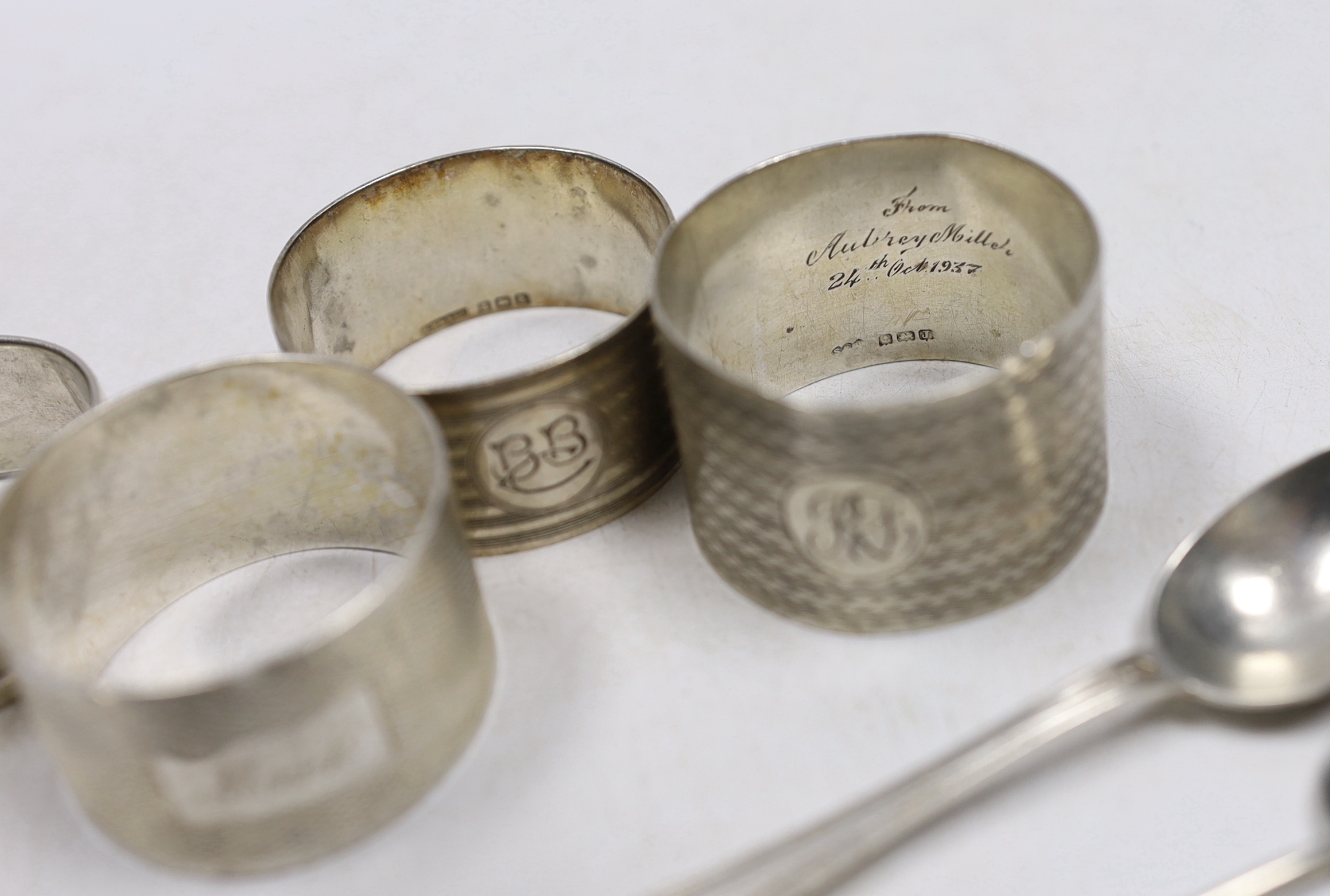 Four assorted silver napkin rings, six assorted silver coffee spoons including four with 'imp' terminals and four continental white metal coffee spoons.